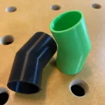 Two plastic, conical-shaped adapters to connect a Festool Track Saw to the dust collection hose