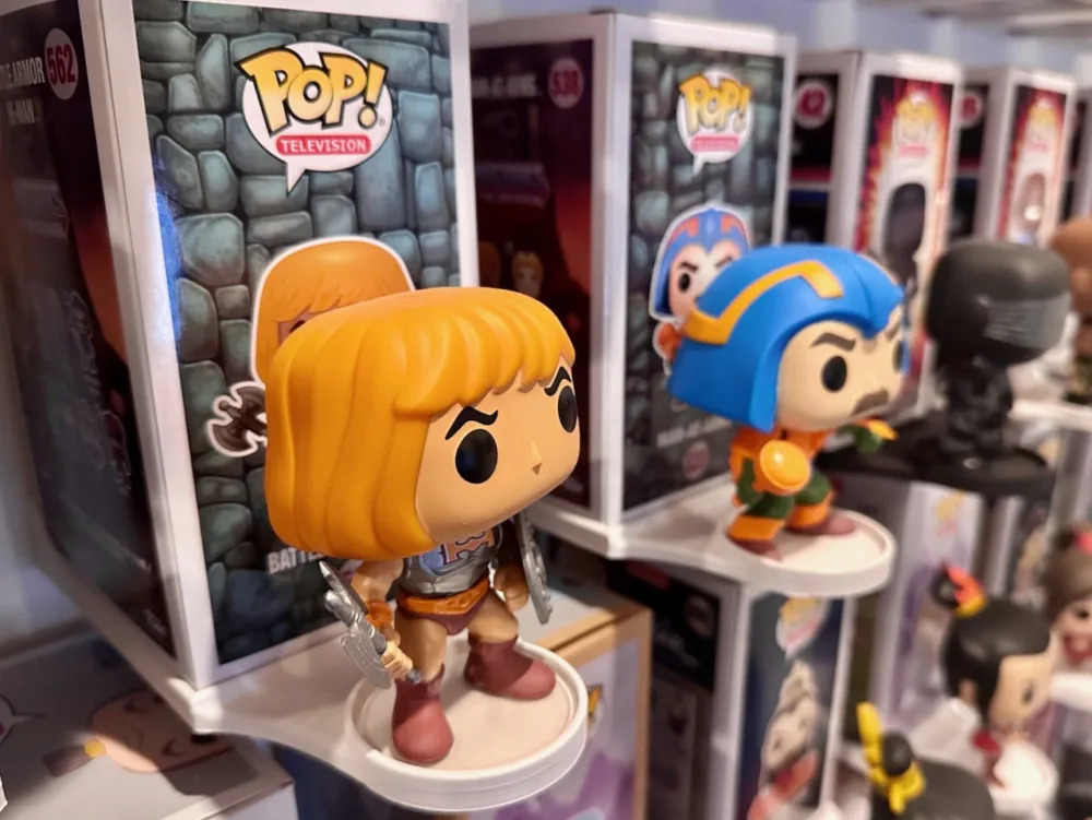 Funko Pop wall mount holding a He-Man Funko Pop figure and it's box